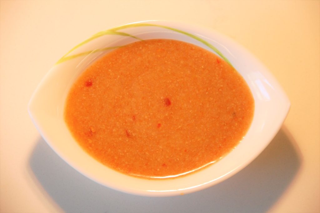 Bowl of creamy orange soup with spices.