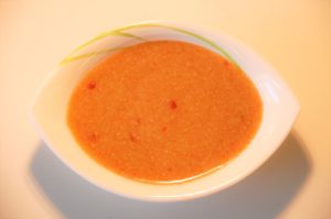 Bowl of creamy orange soup with spices.